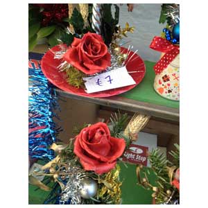 Piatto con rosa rossa stabilizzata e decorazioni natalizie