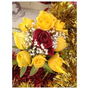 Composizione di fiori e rose trattate con cera gialle e rosse per centrotavola