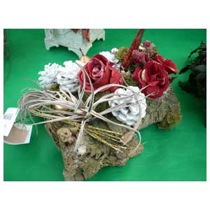 Composizione floreale autunnale con pigne, legno e rose stabilizzate con cera