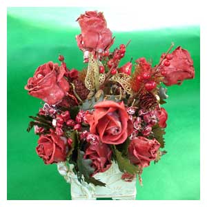 Composizioni floreali autunnali con roselline trattate con cera bacche e pigne